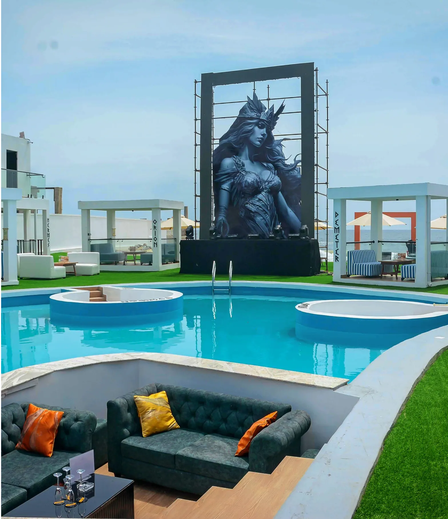 Athena Beach — pool and named cabanas, with the sea beyond